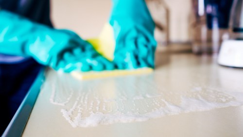Cleaner using protective equipment while operating carpet cleaning machinery